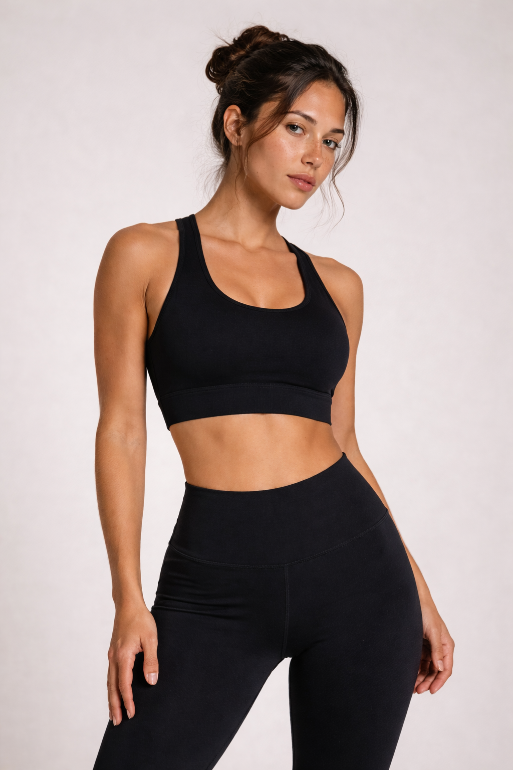Femme portant l’ensemble activewear AURA Black GLIIMA, composé d’un legging taille haute et d’une brassière assortie, vue de face rapprochée.