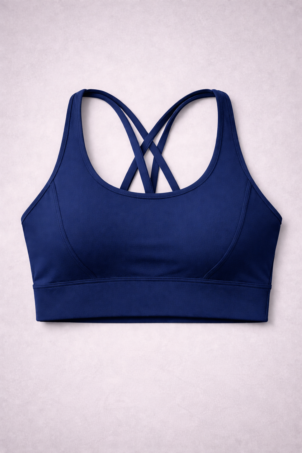 Brassière de sport AURA Dark Navy GLIIMA présentée à plat, avec fines bretelles croisées dans le dos.