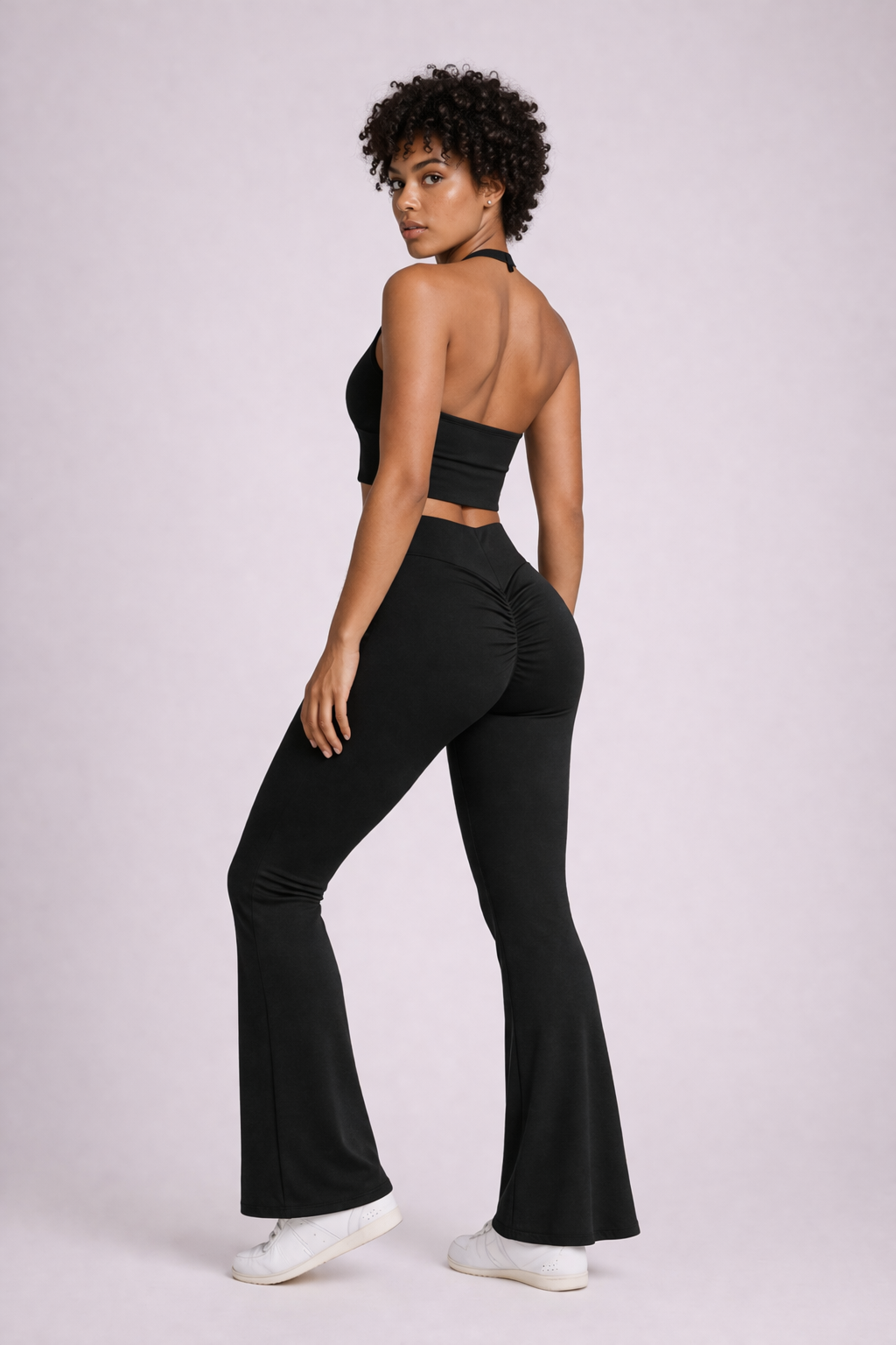 Vue de dos en pied de l’ensemble activewear LYRA Black GLIIMA, avec legging flare taille haute à léger scrunch et haut halter dos nu.