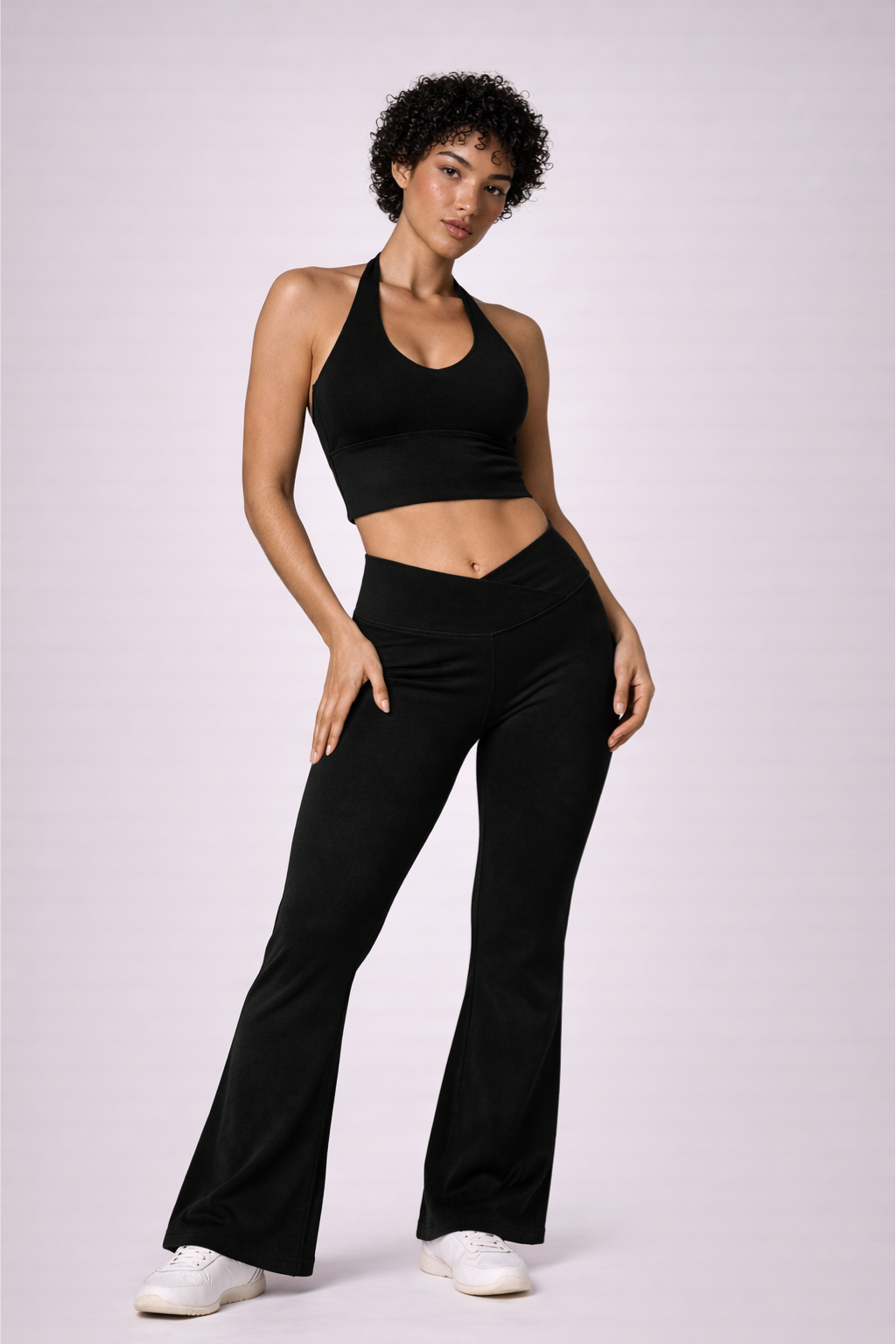 Vue de face en pied de l’ensemble activewear LYRA Black GLIIMA, avec legging flare taille haute croisée en V et brassière col halter.
